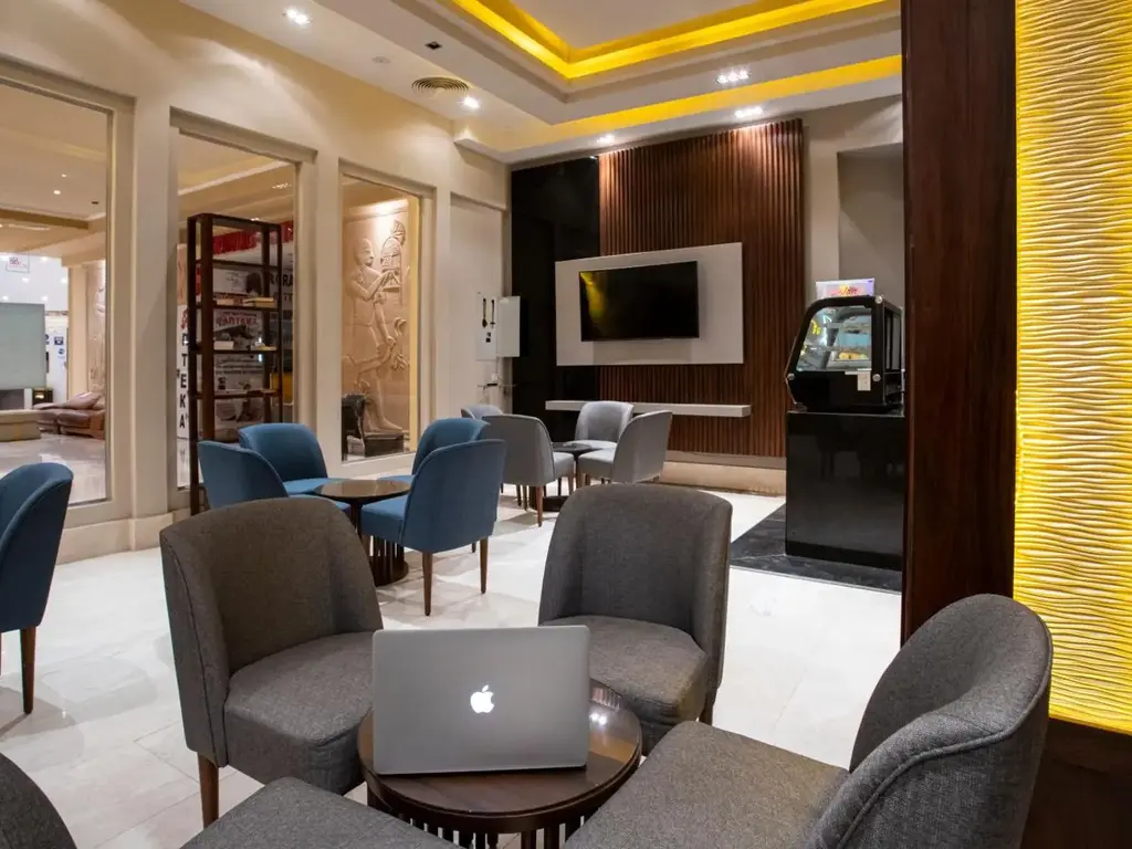 Бизнес кът в лобито със сиви кресла и лаптоп – AMC Royal Hotel & Spa, Хургада