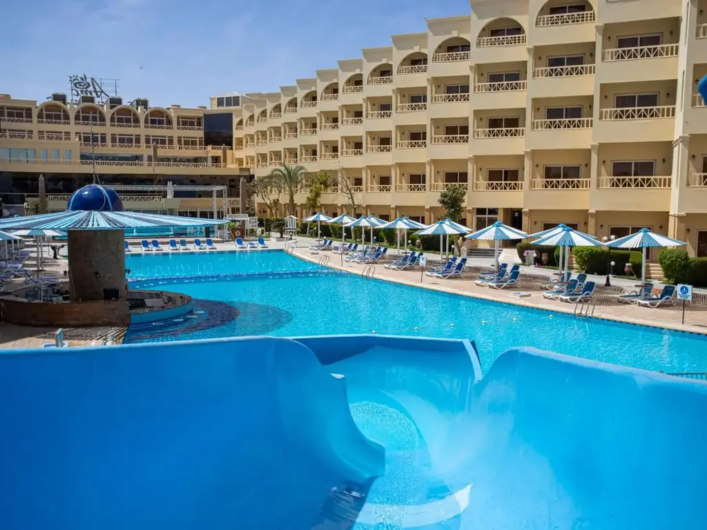 Пързалка край басейна с шезлонги и чадъри пред сградите – AMC Royal Hotel & Spa, Хургада