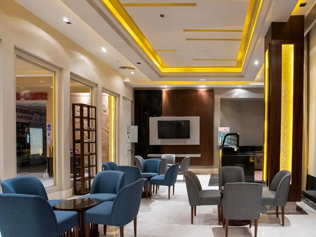 Кът за сядане в лобито със сини кресла и телевизор – AMC Royal Hotel & Spa, Хургада