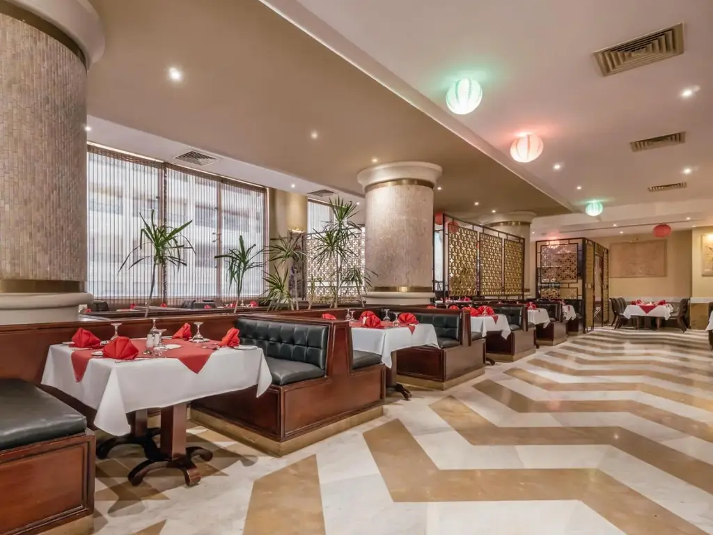 Ресторант с червени салфетки, сепарета и шарен под – AMC Royal Hotel & Spa, Хургада