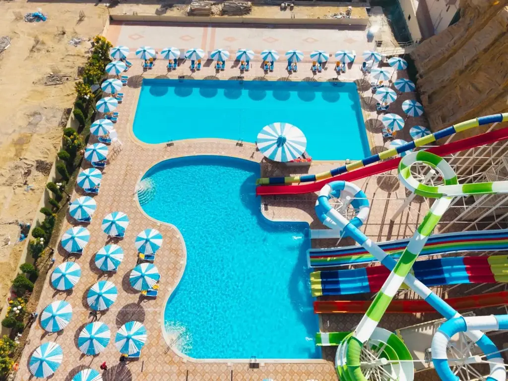 Басейн в аквапарка с червени и зелени пързалки отвисоко – AMC Royal Hotel & Spa, Хургада