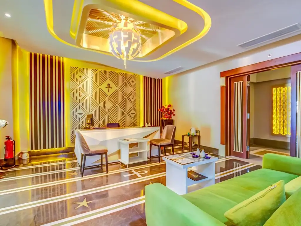 Кът в лобито със зелен диван, бюро и осветен таван – AMC Royal Hotel & Spa, Хургада