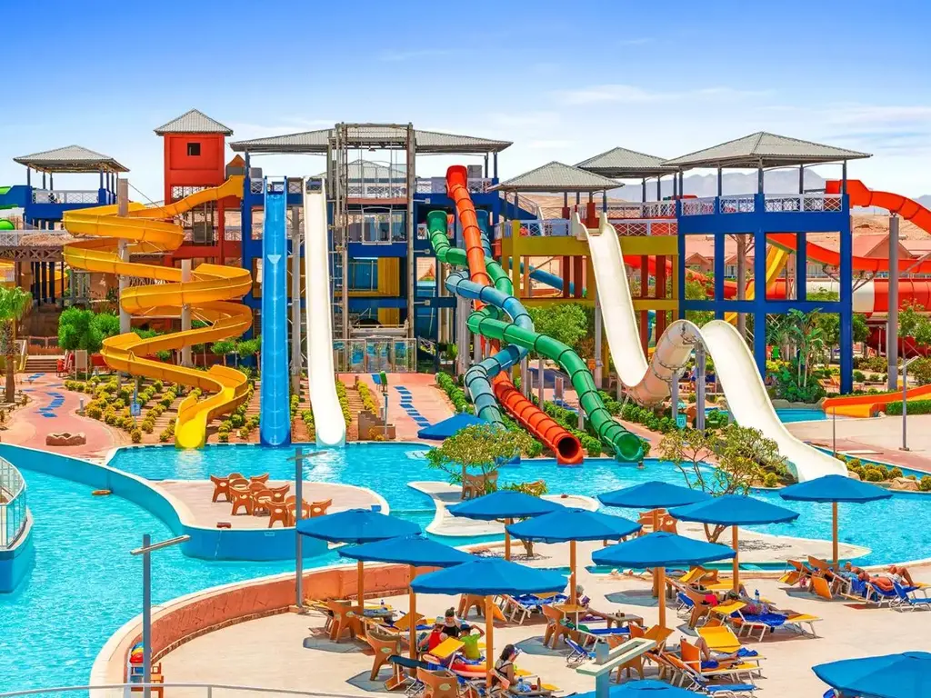 Кули с пързалки до басейна със сини чадъри – Pickalbatros Jungle Aqua Park Resort - Neverland Hurghada, Хургада