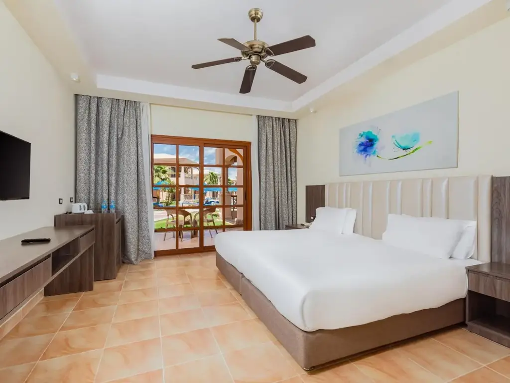 Двойно легло, вентилатор и врата към тераса – Pickalbatros Jungle Aqua Park Resort - Neverland Hurghada, Хургада