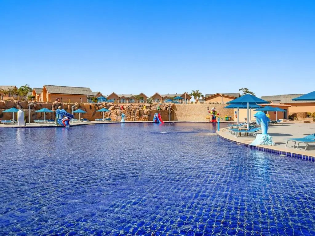 Голям басейн с водни атракции в далечината – Pickalbatros Jungle Aqua Park Resort - Neverland Hurghada, Хургада