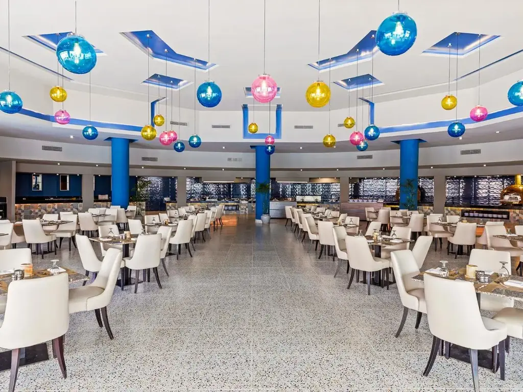 Просторна зала с бели столове и сини колони – Pickalbatros Jungle Aqua Park Resort - Neverland Hurghada, Хургада