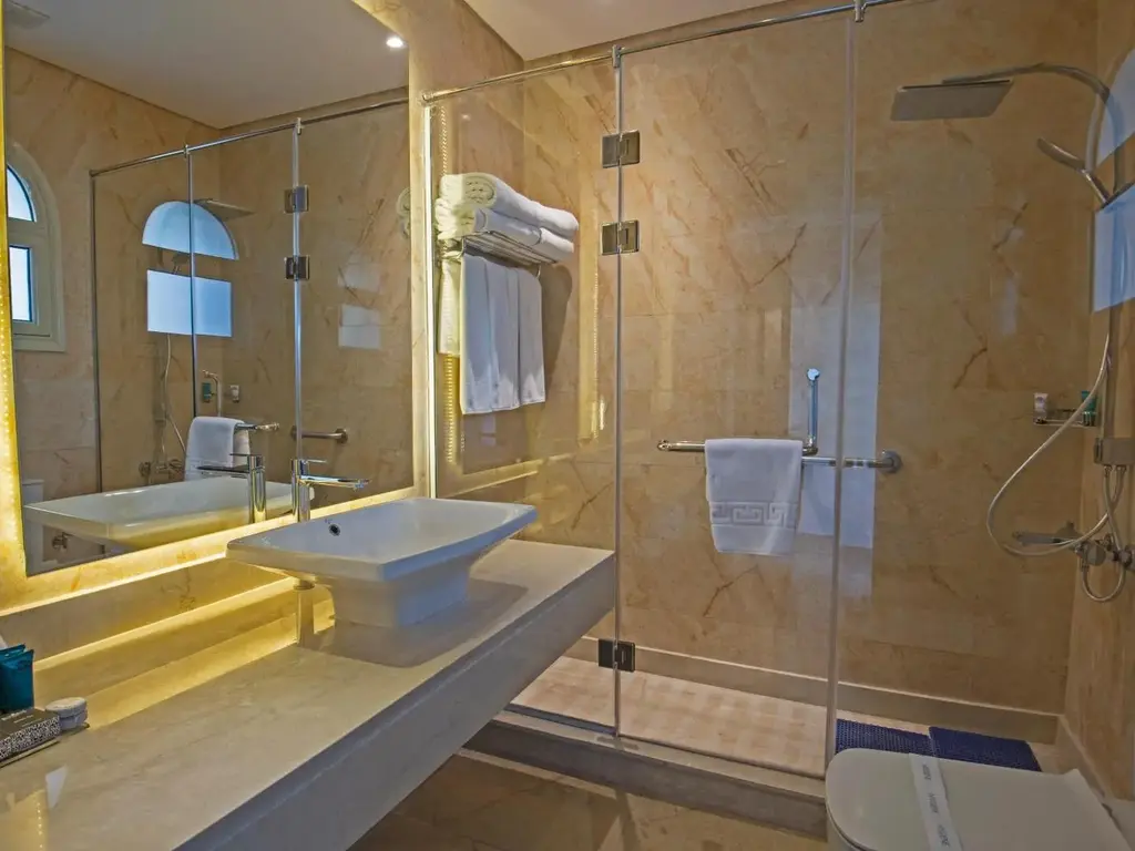 Баня с мраморни стени, стъклен душ и мивка върху плот – Sunrise Aqua Joy Resort, Хургада