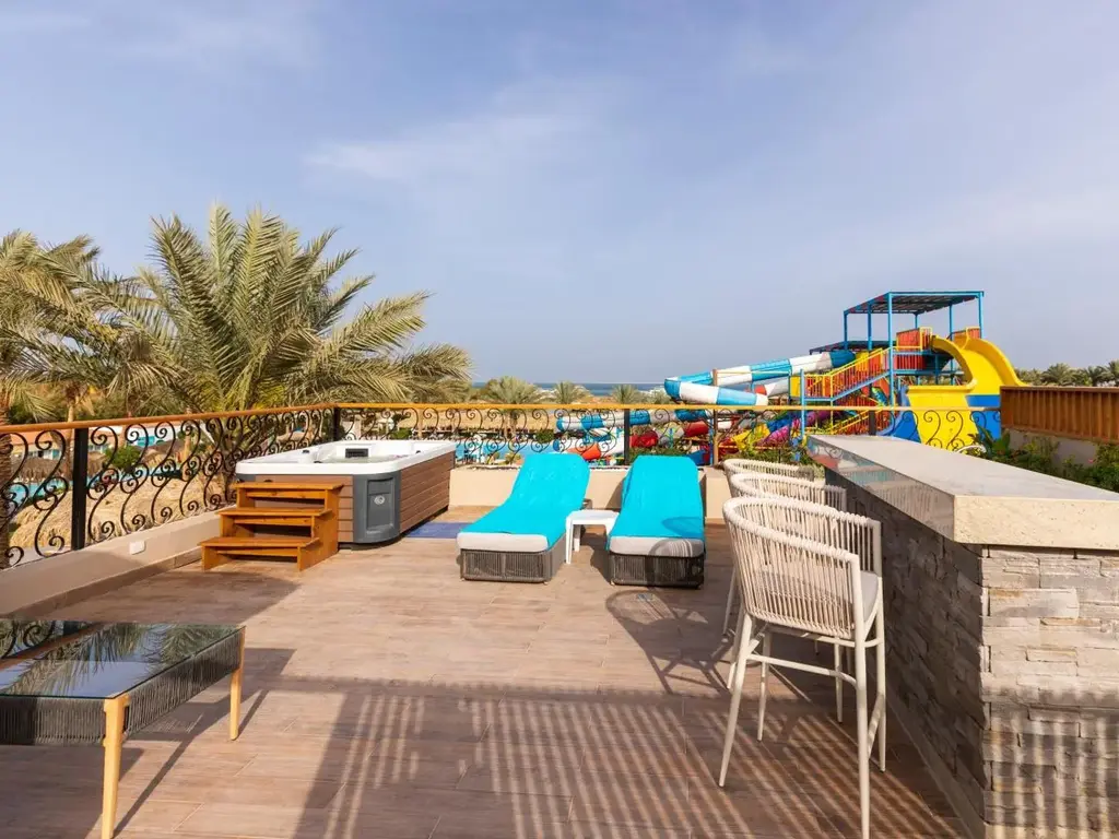 Тераса с джакузи, шезлонги и изглед към пързалките на аквапарка – Sunrise Aqua Joy Resort, Хургада