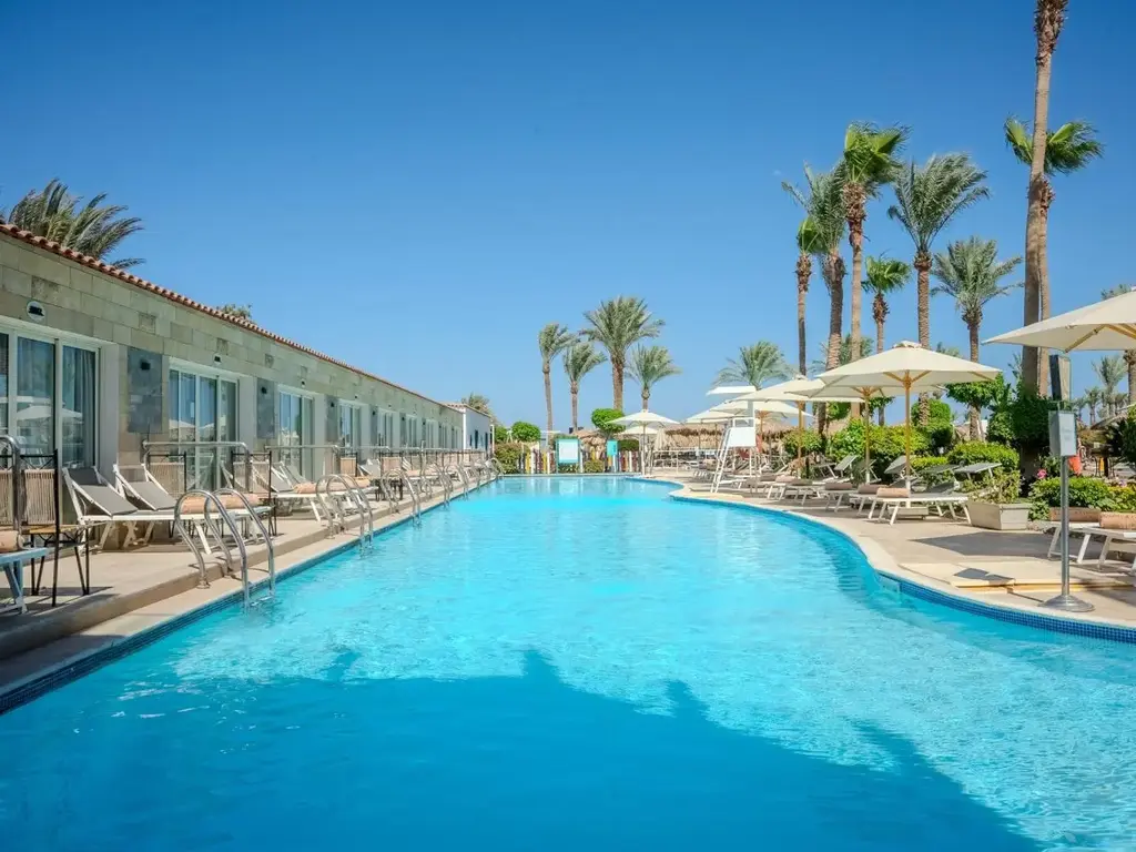Дълъг басейн покрай стаите с директен достъп и палми наоколо – Sunrise Aqua Joy Resort, Хургада