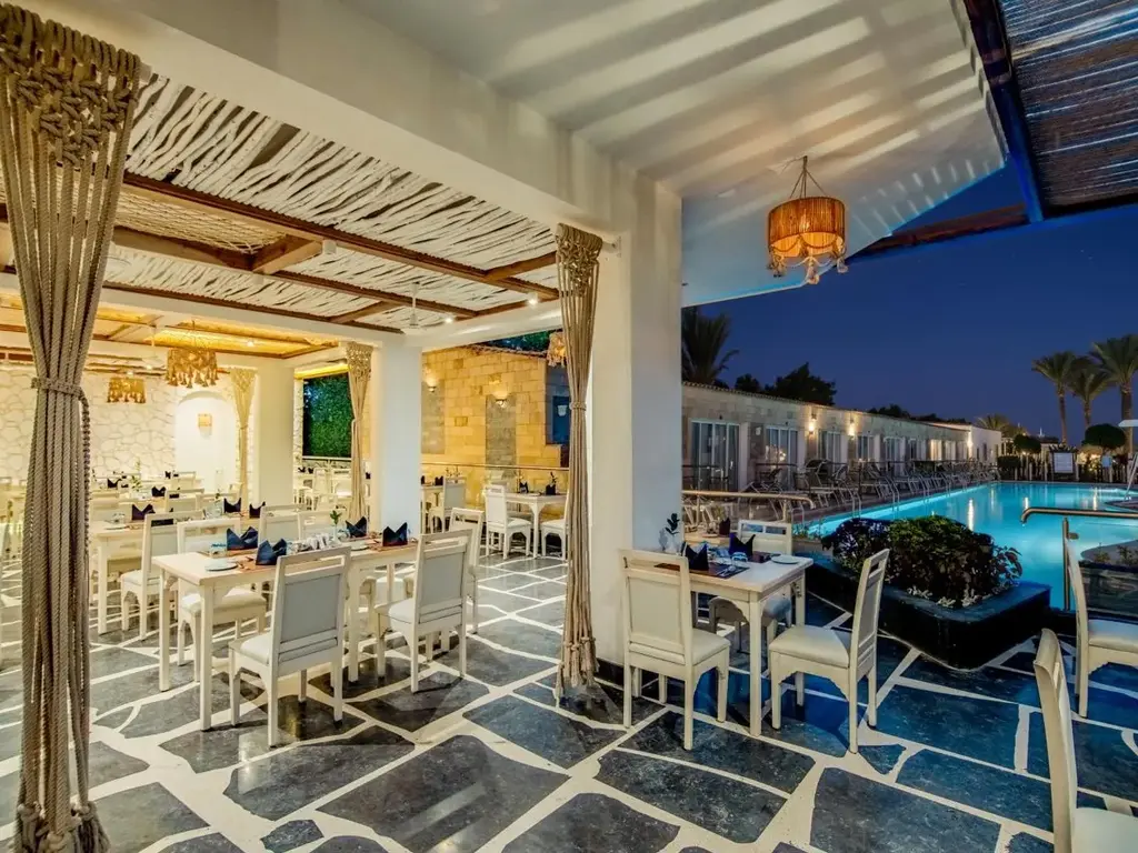 Покрита тераса с бели маси до осветения басейн вечер – Sunrise Aqua Joy Resort, Хургада