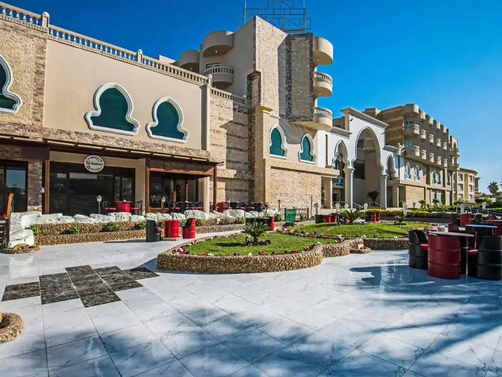 Главната сграда с арковидни прозорци и тераса със зеленина – Sunrise Aqua Joy Resort, Хургада