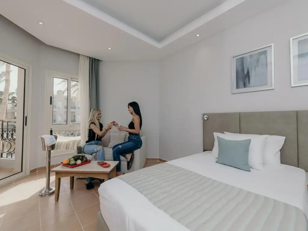Гости пият кафе на масичката до прозореца в стая с двойно легло – Sunrise Aqua Joy Resort, Хургада