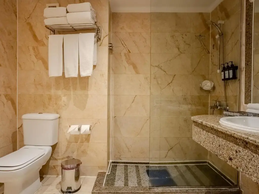 Баня с бежови плочки, кърпи на рафт, тоалетна и душ – Sunrise Aqua Joy Resort, Хургада