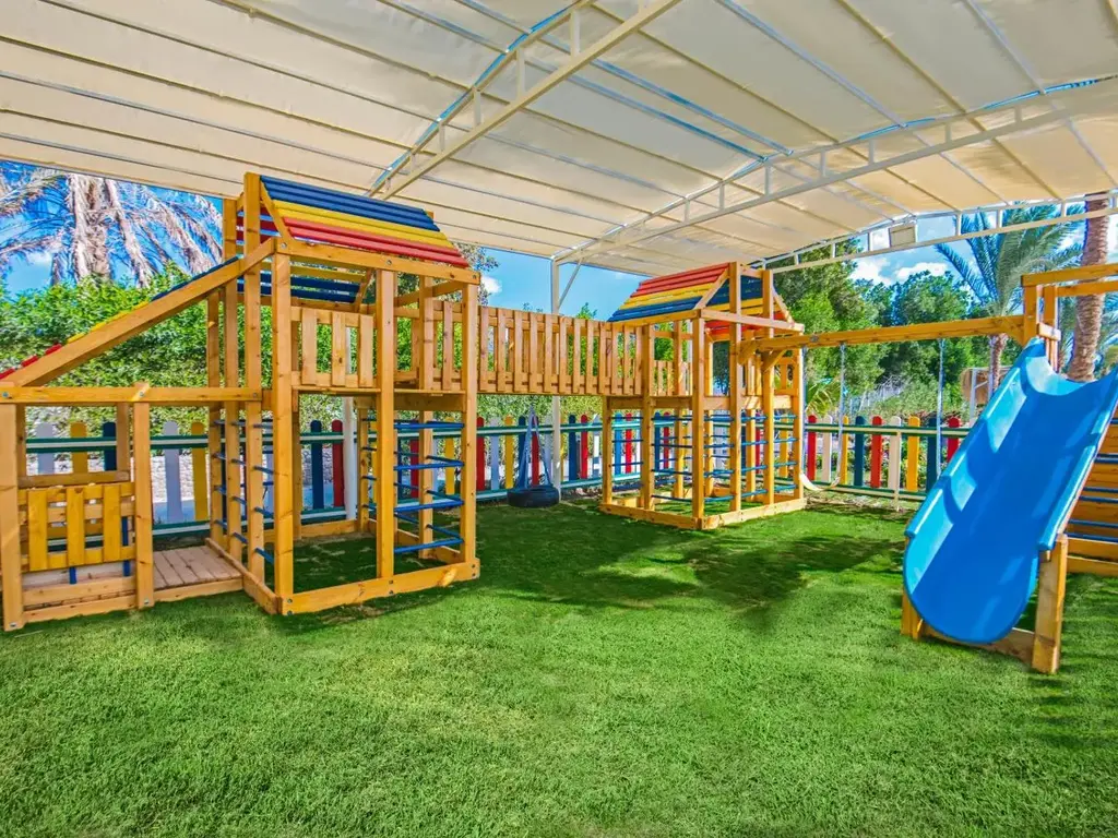 Детска площадка с дървени кули и пързалка под сенник – Sunrise Aqua Joy Resort, Хургада