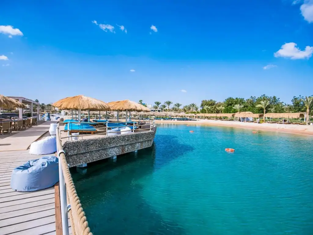 Дървен кей с пуфове, сламени чадъри и тюркоазено море – Sunrise Aqua Joy Resort, Хургада